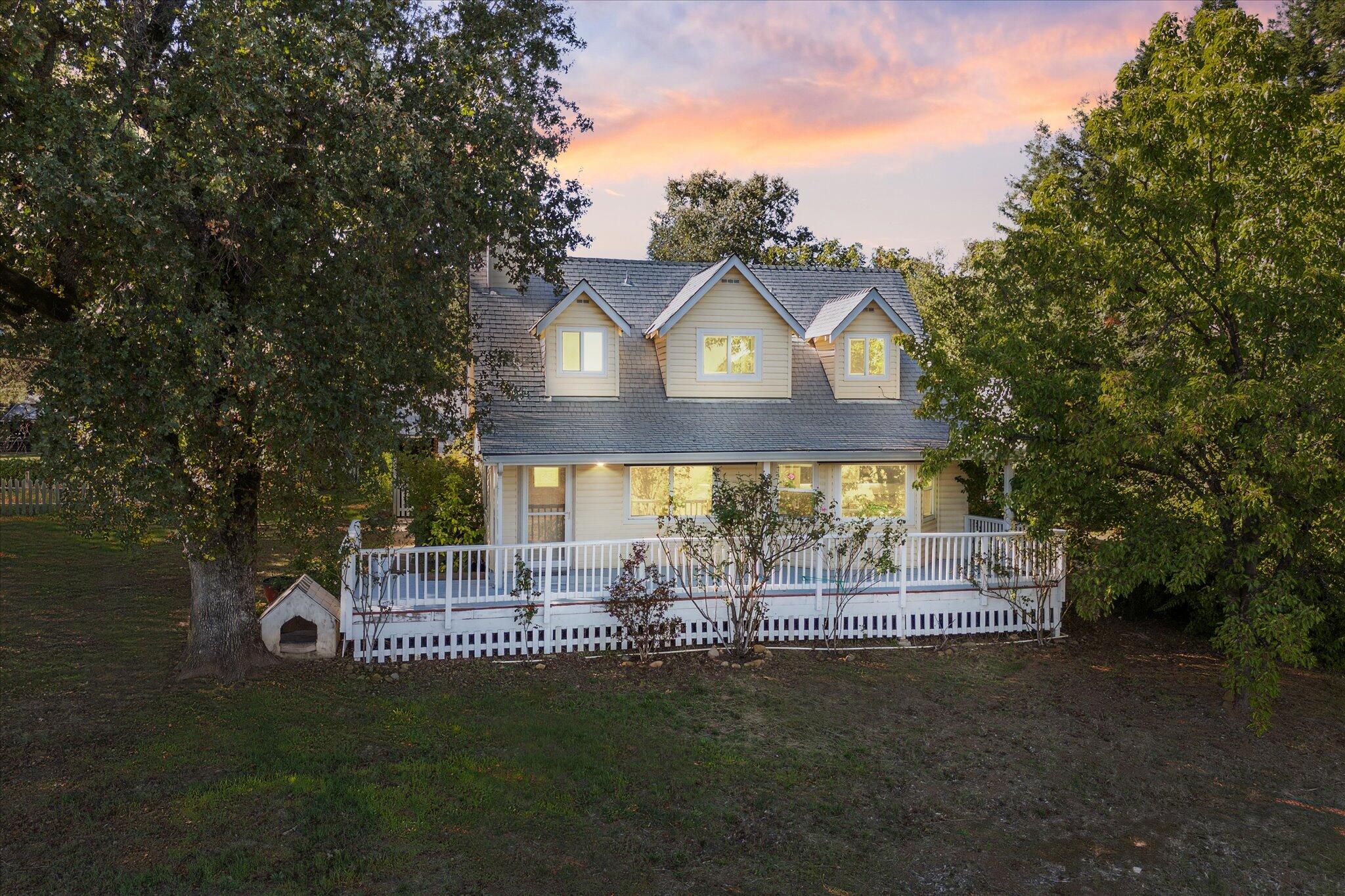 10241 Deschutes Road Palo Cedro, CA 96073 - Photo 2 of 56 a front view of a house with a garden and trees