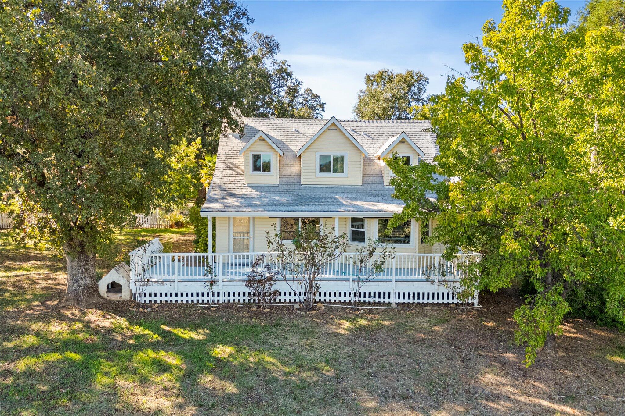 10241 Deschutes Road Palo Cedro, CA 96073 - Photo 49 of 56 a front view of a house with a yard fountain and large tree