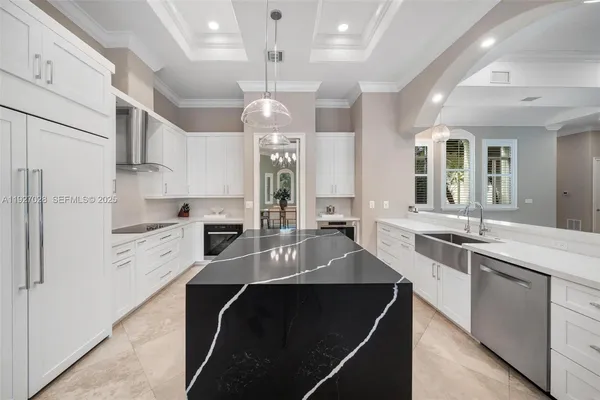 a kitchen with kitchen island granite countertop a sink cabinets and stainless steel appliances