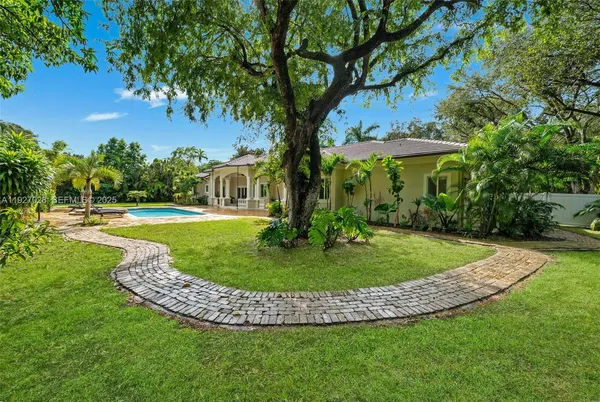 an aerial view of a house with a yard and large trees