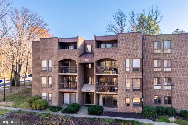 a front view of a residential apartment building with a yard