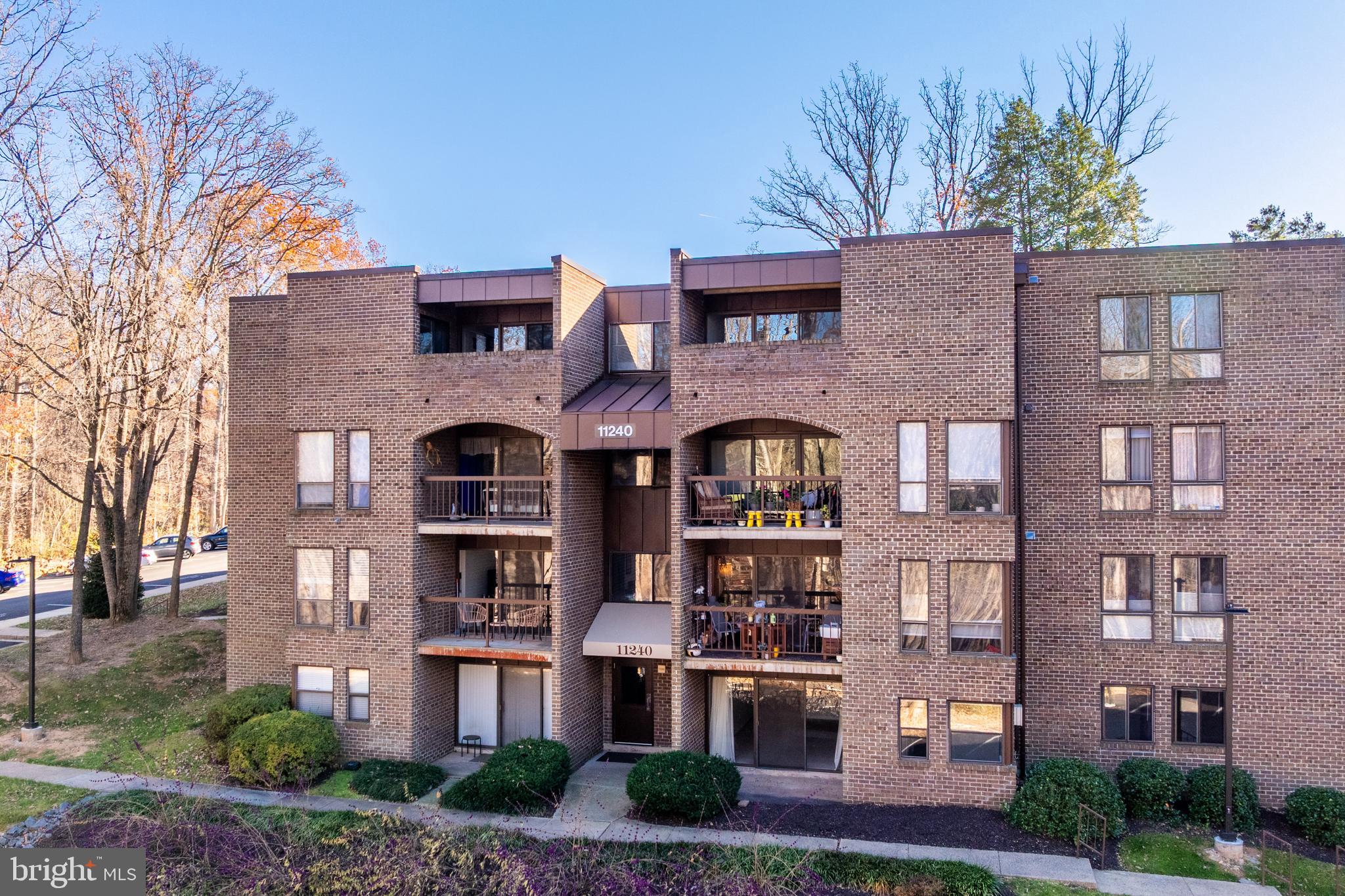 11240 Chestnut Grove Square, Unit 31 Reston, VA 20190 - Photo 1 of 34 a front view of a residential apartment building with a yard