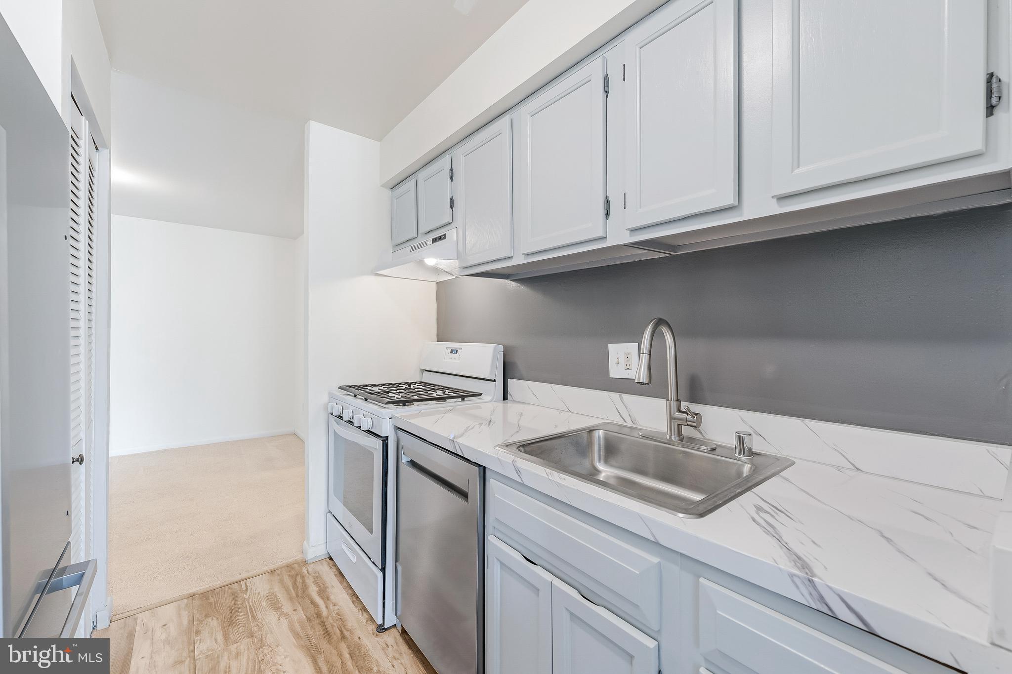 11240 Chestnut Grove Square, Unit 31 Reston, VA 20190 - Photo 3 of 34 a kitchen with stainless steel appliances granite countertop a sink and a white cabinets