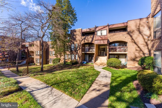 a view of residential houses with yard and trees