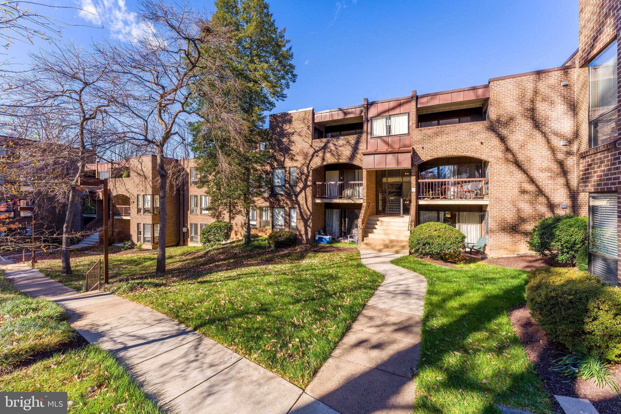 11240 Chestnut Grove Square, Unit 31 Reston, VA 20190 - Photo 32 of 34 a view of a brick building next to a yard