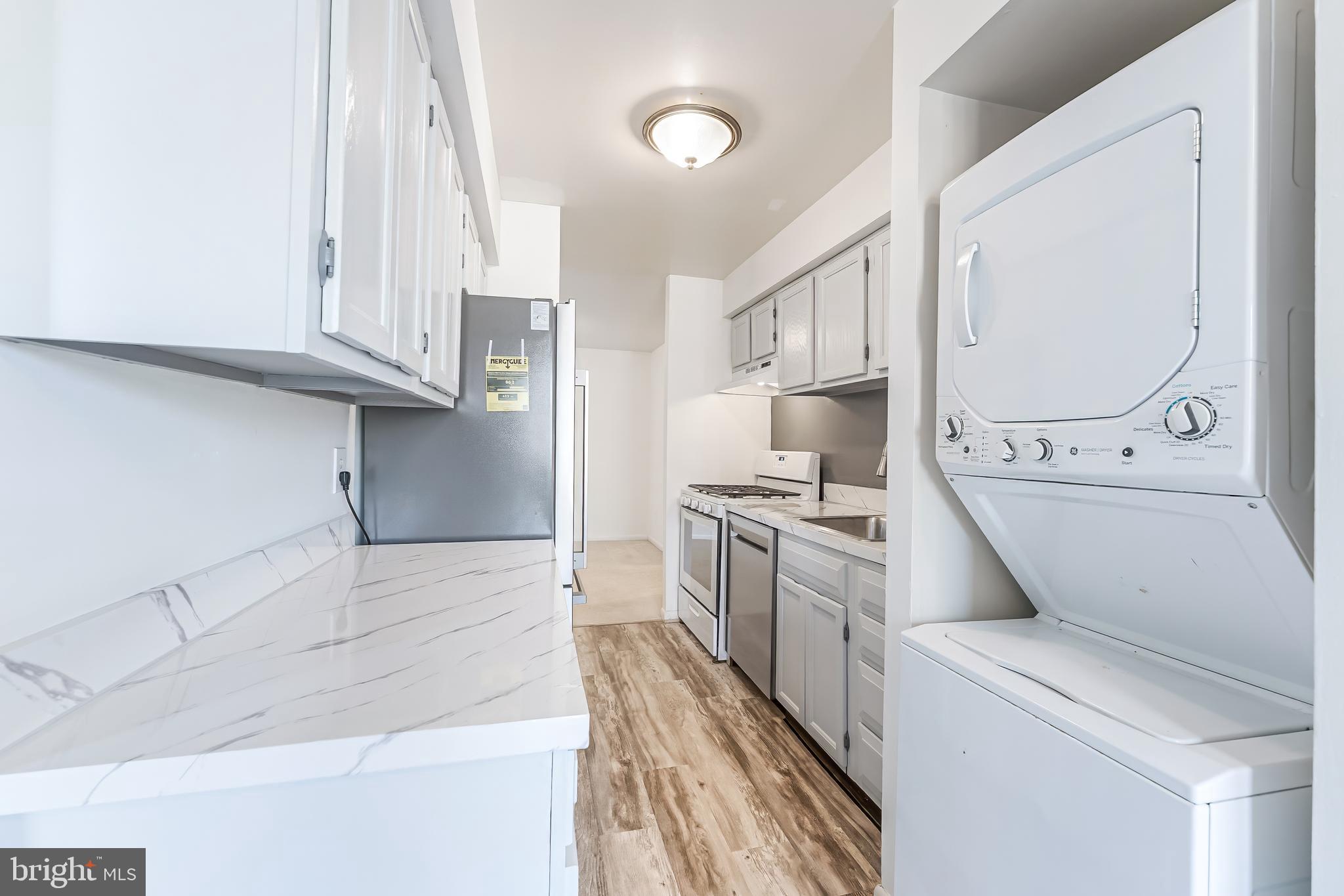 11240 Chestnut Grove Square, Unit 31 Reston, VA 20190 - Photo 6 of 34 a kitchen with white cabinets and white appliances
