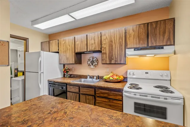 a kitchen with a stove a refrigerator and a sink