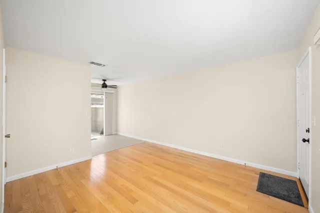a view of empty room with wooden floor