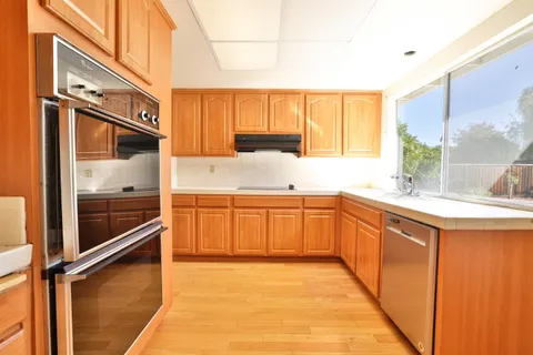 a kitchen with stainless steel appliances a sink and cabinets