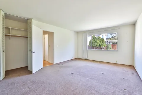 an empty room with windows and closet