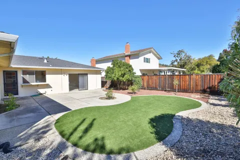 a view of a house with backyard and sitting area