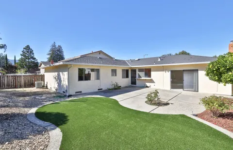 a view of a house with a yard and sitting area