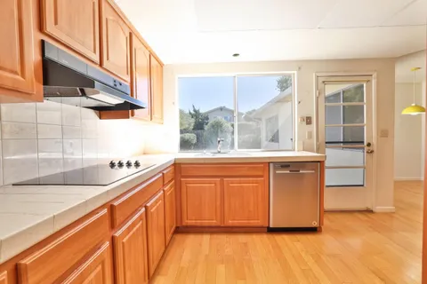 a kitchen with stainless steel appliances granite countertop a stove a sink and a refrigerator