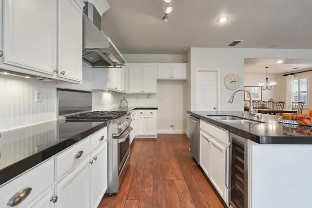 a kitchen with stainless steel appliances granite countertop a sink stove and cabinets
