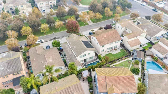 an aerial view of a house with a yard and a lot of flower plants