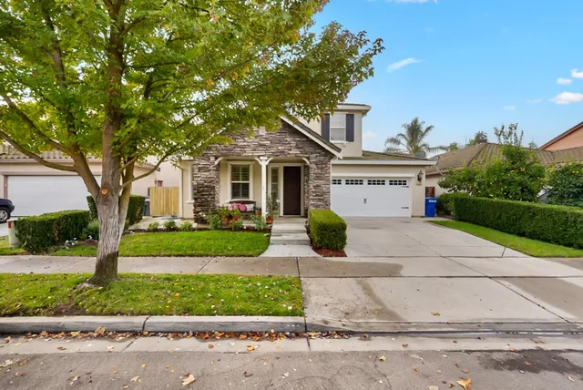 a front view of a house with a yard and a garage
