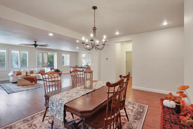 a dining room with furniture a chandelier and wooden floor
