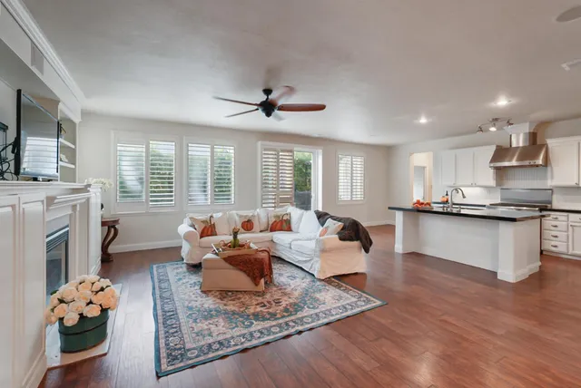 a living room with fireplace furniture and a wooden floor