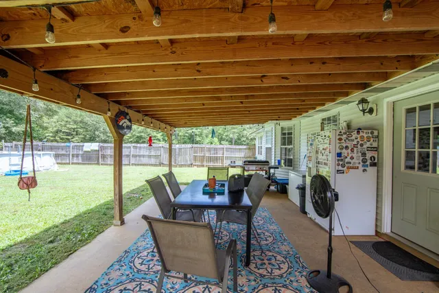 a view of a patio with table and chairs potted plants with floor to ceiling window