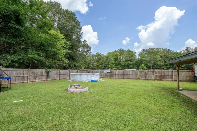 a backyard of a house with table and chairs
