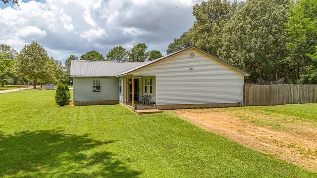 a kitchen with stainless steel appliances granite countertop a stove a sink and white cabinets with wooden floor
