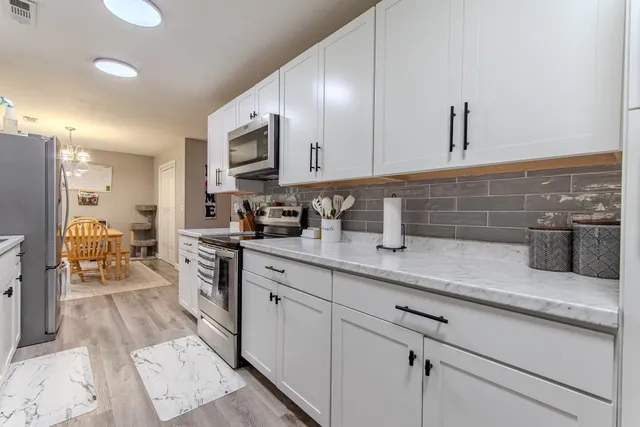 a kitchen with stainless steel appliances a sink a stove and cabinets