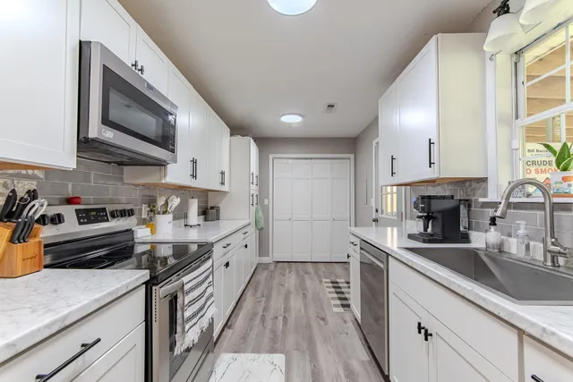 a kitchen with a sink window and cabinets