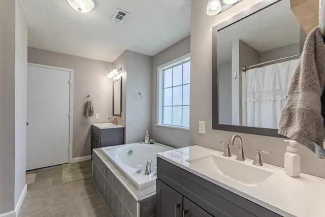 a bathroom with a tub a sink and a window