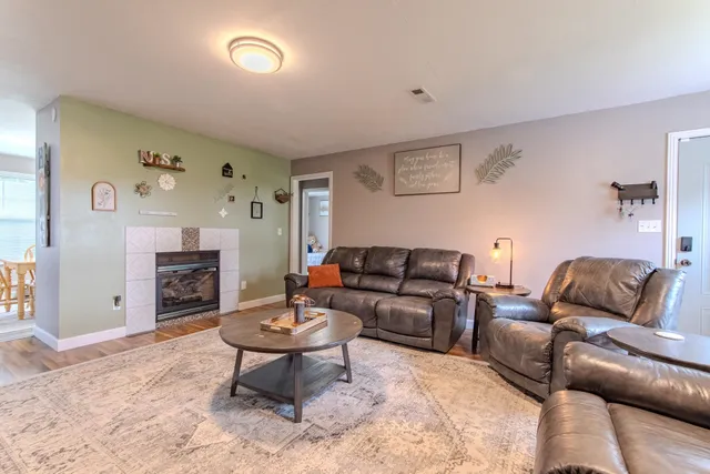 a living room with furniture a fireplace and a flat screen tv