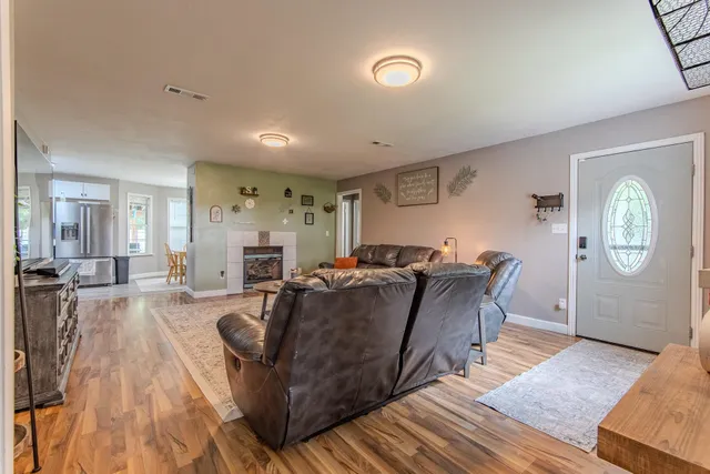 a living room with furniture a fireplace and a chandelier