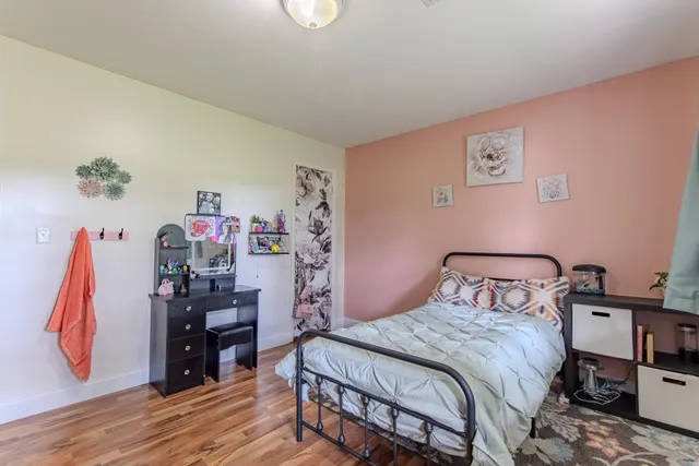 a bedroom with a bed and a wooden floor