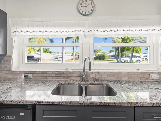 a kitchen with granite countertop a sink and a window