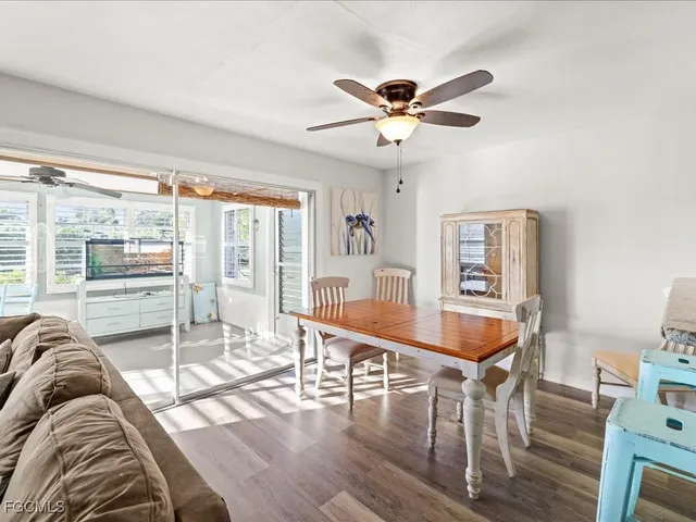 a view of a livingroom with furniture a ceiling fan and wooden floor