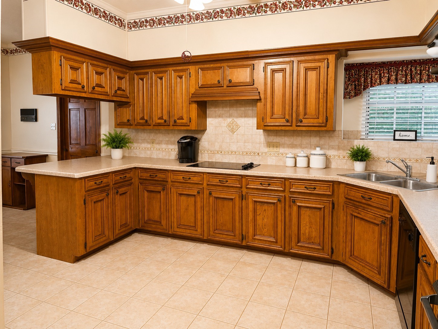 5518 Lacreek Lane Spring, TX 77379 - Photo 5 of 29 KITCHEN – Spacious kitchen featuring abundant warm wood cabinetry, generous counter space, tile flooring and backsplash, a smooth cooktop, double sink, and convenient breakfast bar. A large window over the sink brings in natural light, while the expansive layout offers plenty of workspace and storage.
