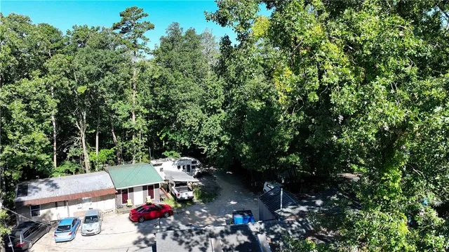 a view of a house with a yard and a car park