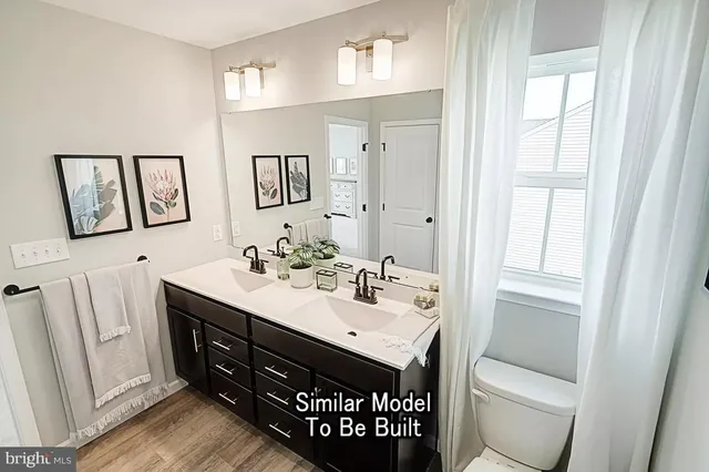 a bathroom with a toilet a sink a mirror and a window