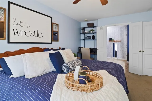 a spacious bedroom with a bed a couch and a chandelier