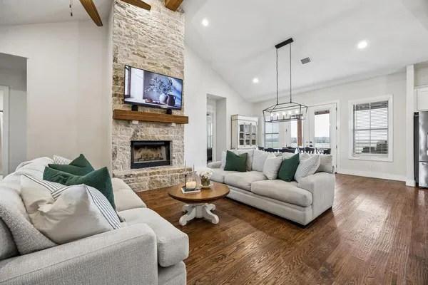 a living room with furniture kitchen view and a fireplace