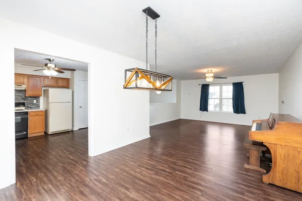 a view of a room with wooden floor kitchen view and a window