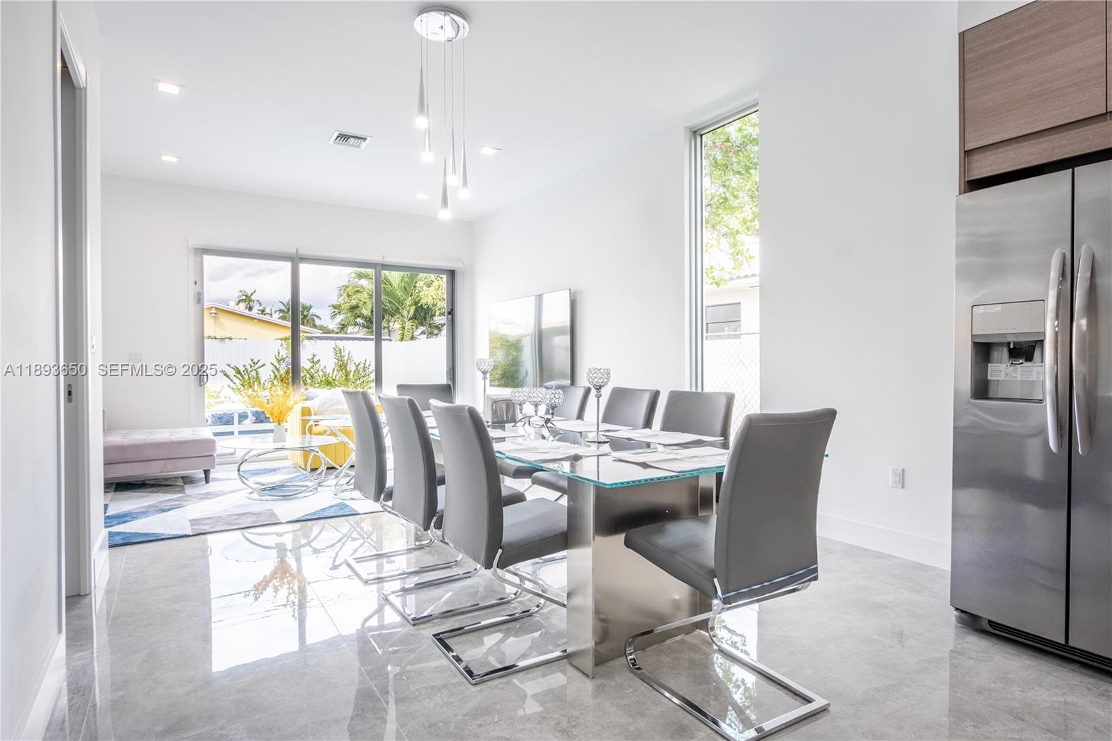 3461 Southwest 25th Street, Unit B Miami, FL 33133 - Photo 4 of 23 a dining room with furniture a window and a kitchen view