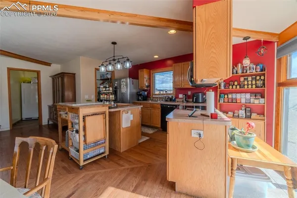 a kitchen with stainless steel appliances granite countertop a table chairs and a refrigerator