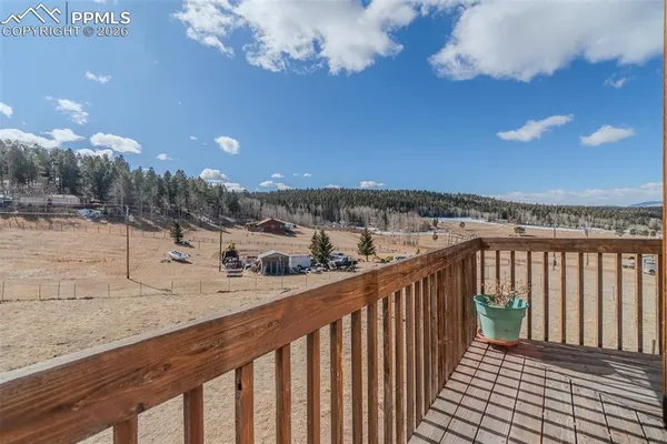 a view of a balcony with wooden floor and fence
