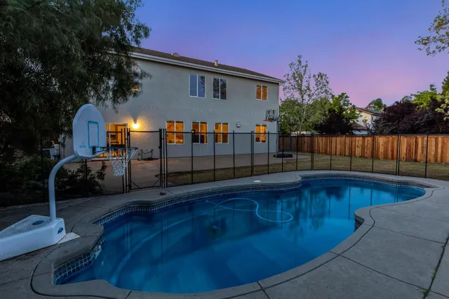 a view of a backyard with swimming pool in the background