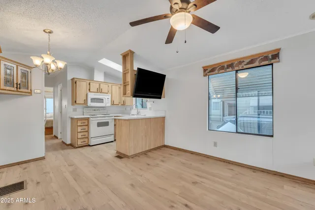 a kitchen with stainless steel appliances kitchen island granite countertop a stove a sink and a wooden floors