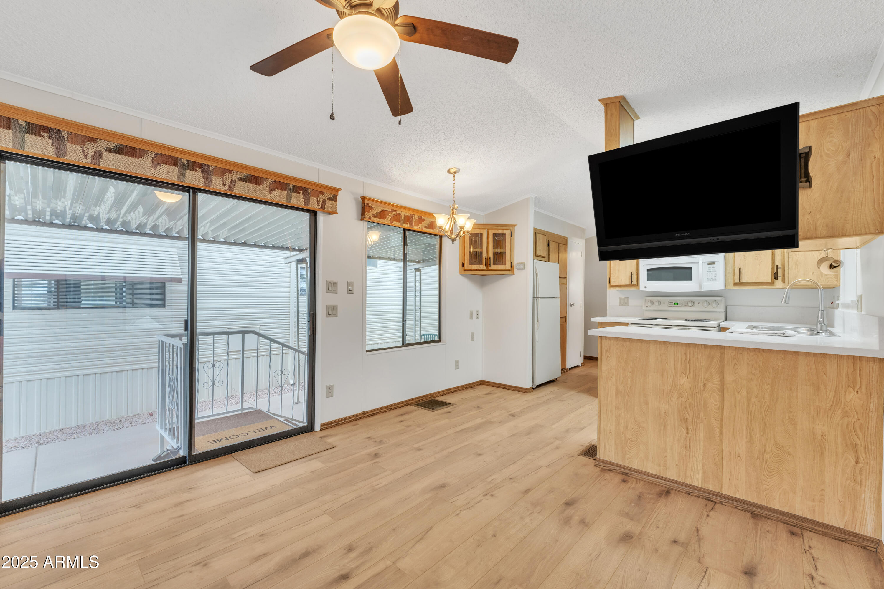 1152 South Sioux Drive Apache Junction, AZ 85119 - Photo 12 of 50 a view of a livingroom with wooden floor and a flat screen tv