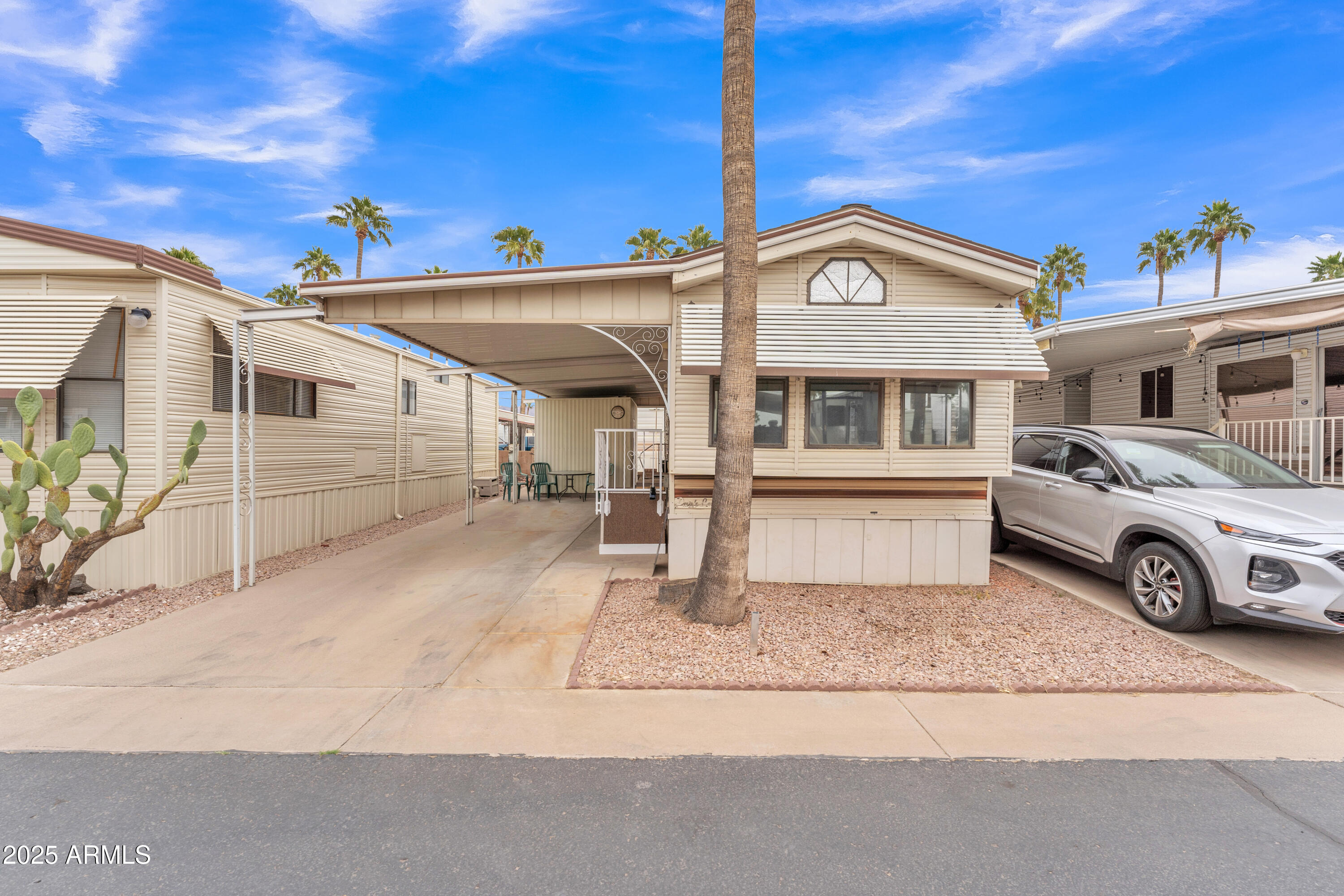 1152 South Sioux Drive Apache Junction, AZ 85119 - Photo 7 of 50 a view of a white house with large windows and palm tree