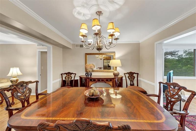 30 Chaumont Square Northwest Atlanta, GA 30327 - Photo 11 of 44 a dining room with wooden floor a chandelier fan a wooden table and chairs