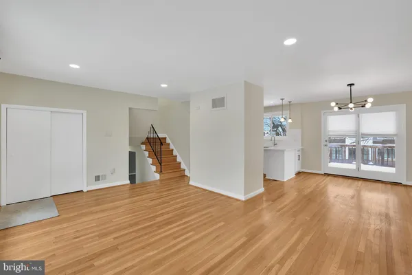a view of a big room with wooden floor and a kitchen