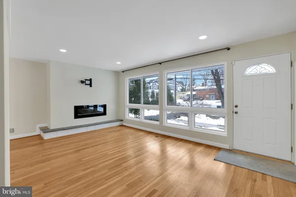 a view of empty room with wooden floor and fireplace