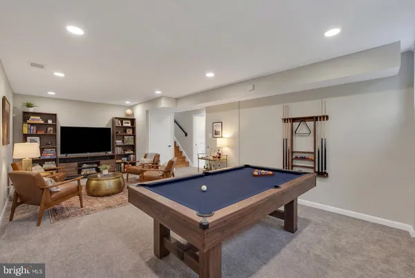 a living room with furniture flat screen tv and windows